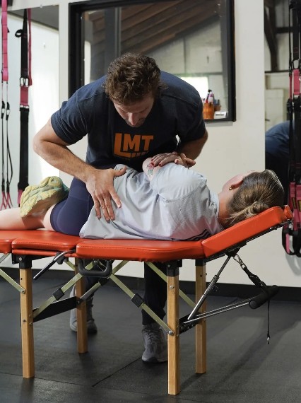 Dr. Nate Leer providing hands-on care to a patient on a treatment table